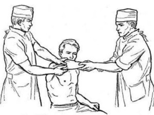 Доктора вправляют пациенту плечо 